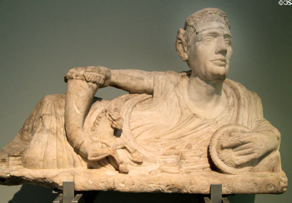 Etruscan carved alabaster cinerary urn lid with reclining man holding horse rhyton (200-100 BCE) prob. from Volterra at British Museum. London, United Kingdom.