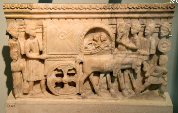 Etruscan carved alabaster cinerary urn front panel of chest with couple riding on covered wagon (100-150 BCE) from Volterra at British Museum. London, United Kingdom.