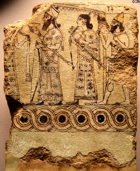 Assyrian glazed terracotta tile shows king with cup & bow in procession (c875-850 BCE) from Palace of Nimrud at British Museum. London, United Kingdom.