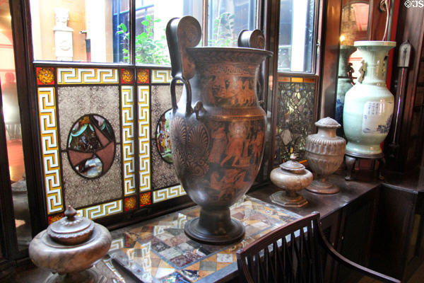 Antique ceramics against stained glass windows in dining area at Sir John Soane's Museum. London, United Kingdom.