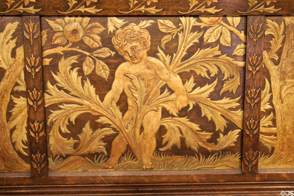 Detail of gilded plasterwork putti on oak settle (1890s) by Philip Webb for Morris & Co at Morris Gallery. London, United Kingdom.