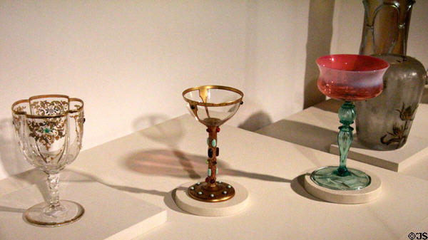 Quadrafoil water glass (c1910-5) from PA; wine glass (c1906) from Bohemia; & Champagne glass (1820) by Tiffany at Mobile Museum of Art. Mobile, AL.