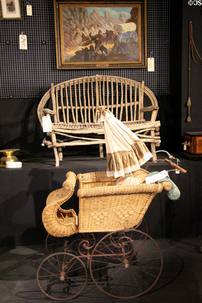 Wicker baby carriage & rustic stick wood bench at Arizona History Museum. Tucson, AZ.