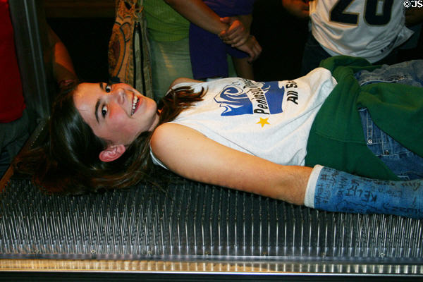 Student tries a bed of nails in California Science Center. Los Angeles, CA.