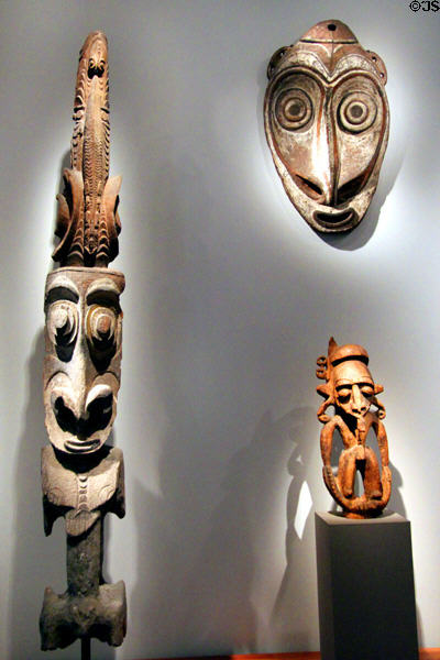 Carved house post (17th-early 19thC) & ceremonial house gable mask (1650-1820) both from Sepik River plus figure (15thC) from Madang all of New Guinea at de Young Museum. San Francisco, CA.