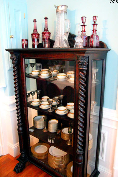 Glass display case with porcelain dinner service in dining room at Pardee Home Museum. Oakland, CA.
