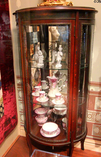 Vitrine with china service from the Gilded Age in San Francisco at Oakland Museum of California. Oakland, CA.