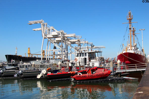 Official boats at Jack London Square docks with cranes beyond. Oakland, CA.