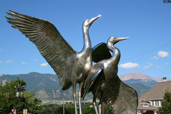 Whooping Cranes Rights of Spring sculpture (1993) by Kent Ullberg against Rocky Mountains near Colorado Springs Fine Arts Center. Colorado Springs, CO.