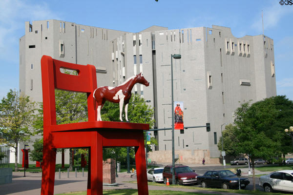Donald Lipski's The Yearling horse on a chair against North building of Denver Art Museum. Denver, CO.