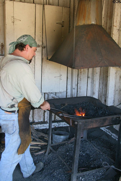 Blacksmith working at forge of Clear Creek History Park. Golden, CO.