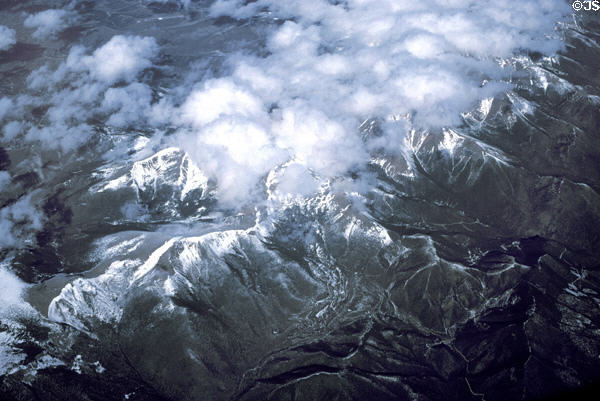 Snow capped ridges & clouds of Rocky Mountains from air. CO.