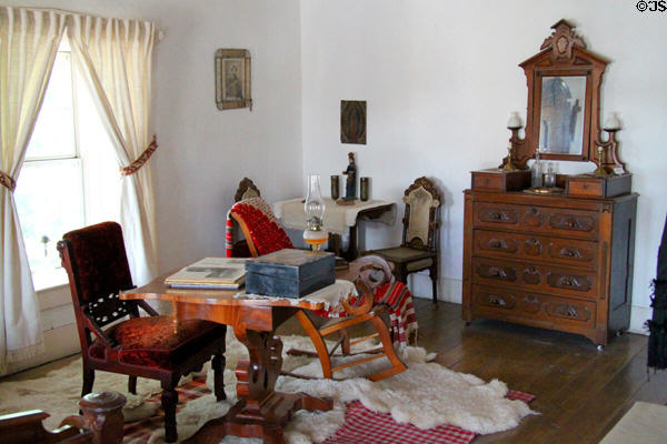 Bedroom with table & dresser at Baca Adobe House. Trinidad, CO.