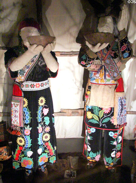 Anishinaabe peoples native dress (late 1800s-early 1900s) with wooden bowls at National Museum of the American Indian. Washington, DC.