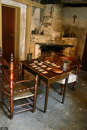 Ground floor room of The Oldest House as furnished in British Colonial times with card table before fireplace. St Augustine, FL.