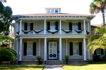 White neoclassical Bronson Cottage with balcony (c1880s) (252 St. George St.) near Old St. Augustine Village. St Augustine, FL. Architect: Andrew Jackson Davis.