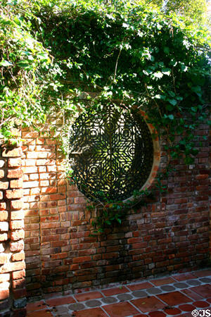 Round window in garden wall at Old St. Augustine Village. St Augustine, FL.