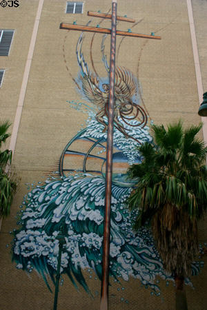Mural of winged god of lightning feeding power poles over waves on Bell South building. Orlando, FL.