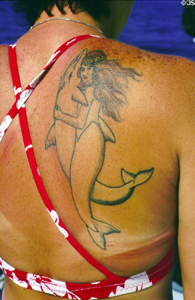 Cruise hostess with dolphin tattoo off Kona coast. Big Island of Hawaii, HI.
