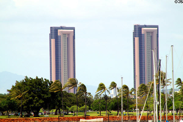 One Waterfront Towers over palm trees. Honolulu, HI.