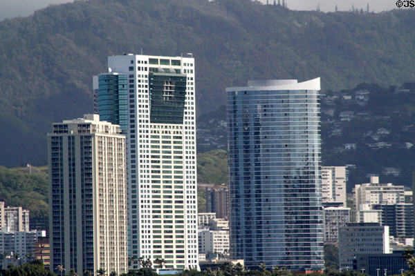 Hawaiki Tower (1999) (45 floors) (88 Piikoi St.) with leaning projections to left of oval Moana Pacific Tower. Honolulu, HI. Architect: Barry Patten + GYA Architects, Inc..
