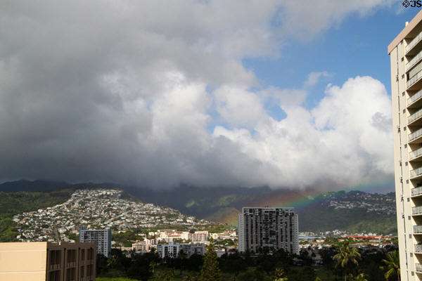 Storm clouds & rainbow over hills of Honolulu north of Waikiki. Waikiki, HI.