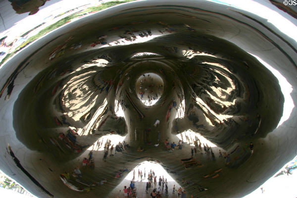The concave underside surface of Cloud Gate in Millennium Park reflect people under the arch. Chicago, IL.