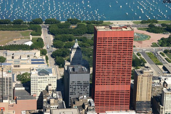 Overview of highrises along Michigan Avenue including red CNA Plaza seen against Grant Park & boats on Lake Michigan. Chicago, IL.