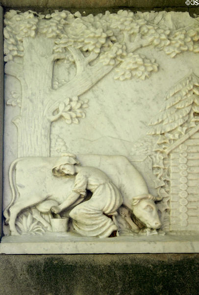 Relief of woman milking cow beside log cabin on Daniel Boone's grave. Frankfort, KY.