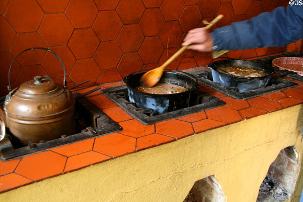 Stirring pots over open flames at outdoor kitchen of Hermann Grima House. New Orleans, LA.