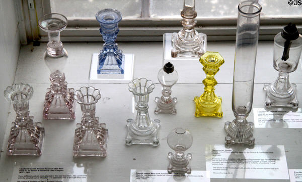 Collection of glass candlesticks & lamps most by Boston & Sandwich Glass Co. at Sandwich Glass Museum. Sandwich, MA.