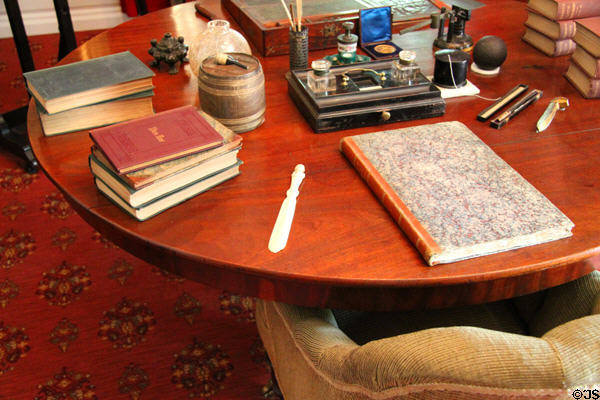 Longfellow's study table with favorite books plus Samuel Taylor Coleridge's inkstand used to write "The Rime of the Ancient Mariner" at Longfellow National Historic Site. Cambridge, MA.
