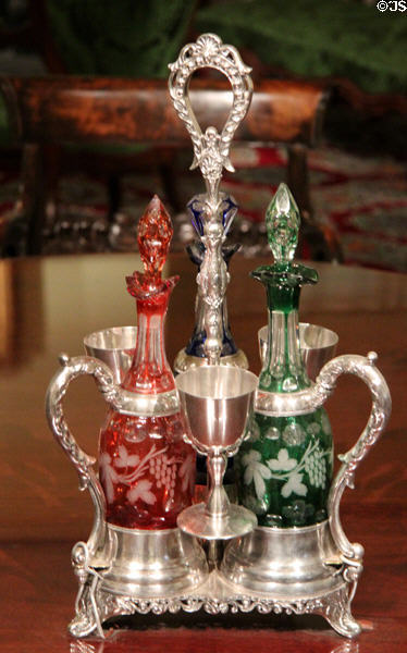 Silver wine decanter set with cups & colored cut glass bottles at Museum of Fine Arts. Boston, MA.
