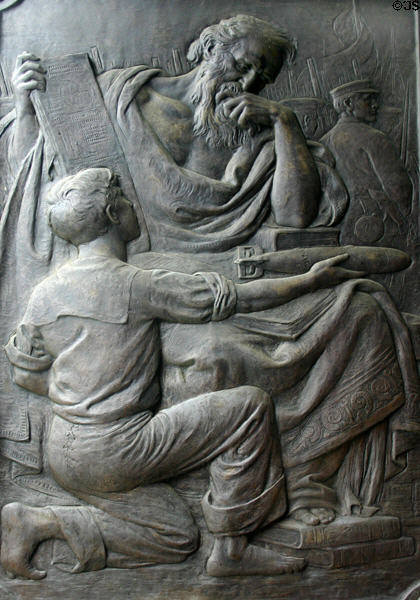 Relief of boy with torpedo & bearded man with math scroll on doors of Naval Academy Chapel. Annapolis, MD.
