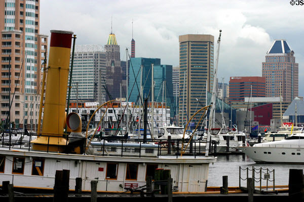 View across antique steam tug boat to skyline of Baltimore with golden Bank of America, brown World Trade Center & blue-roofed Commerce Place (1992) (31 floors) by RTKL Assoc. Baltimore, MD.