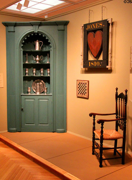 Corner cupboard (1761-80) from Chester, NH with pewter tavern sign & arm chair at Currier Museum of Art. Manchester, NH.