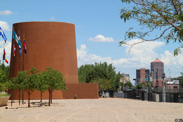 Round tower of National Hispanic Cultural Center overlooks downtown skyscrapers of Albuquerque. Albuquerque, NM.