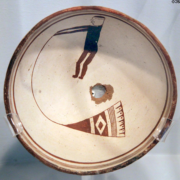 Mimbres classic black-on-white pottery bowl with man with bullroarer (c1000-1150) at Maxwell Museum of Anthropology. Albuquerque, NM.