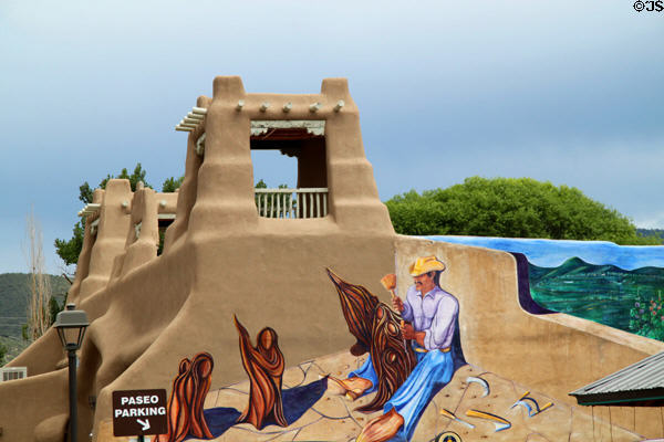 El Santero mural by George Chacon on an adobe revival Cabot Plaza anchors touristic Kit Carson Road. Taos, NM.