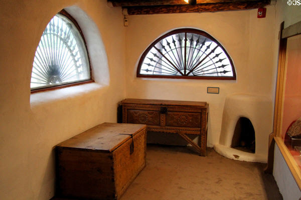 Room with chests, fireplace & semiround windows at Millicent Rogers Museum. Taos, NM.