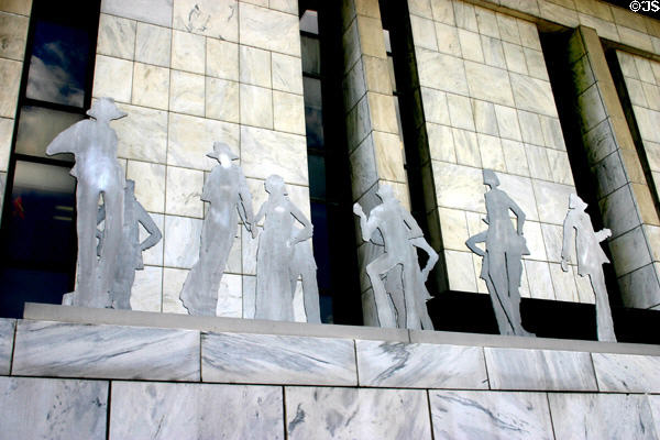 Cutout people sculpture set off by marble of Legislative Office Building. Albany, NY.