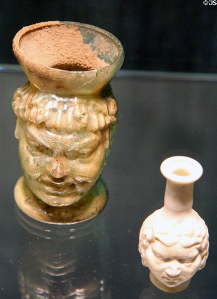 Roman mold-blown glass cup & bottle with faces (2ndC) at Corning Museum of Glass. Corning, NY.