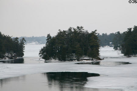 Some of Thousand Islands in St. Lawrence River ringed by ice seen from International Bridge. NY.
