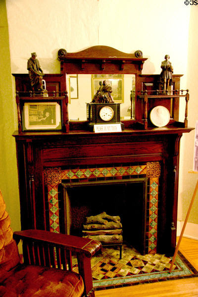 Fireplace with ceramic tile surround with shelves for statues at Susan B. Anthony House. Rochester, NY.