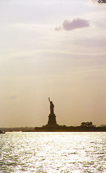 Statue of Liberty in light of setting sun. New York, NY.