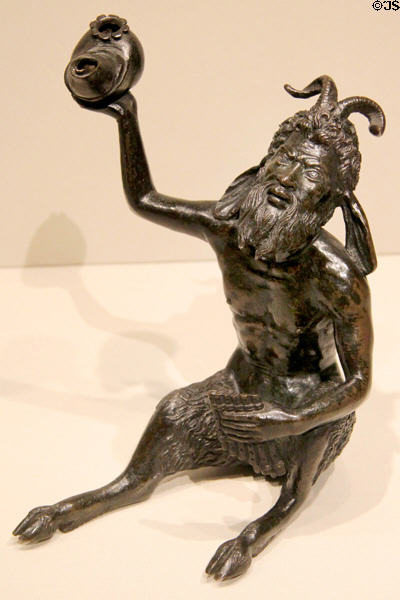 Shell lamp held aloft by seated Satyr with pan pipes bronze statuette (c1515-30) by workshop of RICCIO (Andrea Briosco) of Padua, Italy at Metropolitan Museum of Art. New York, NY.