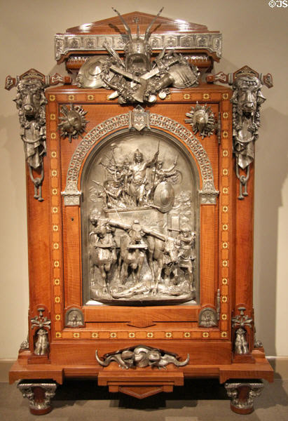 Veneered armoire with silvered mounts & plaque of King Merovech over forces of Attila the Hun in 451 (1867) by Jean Brandely, Charles-Guillaume Diehl & Emmanuel Frémiet of Paris (made for Paris Exposition Universelle of 1867) at Metropolitan Museum of Art. New York, NY.