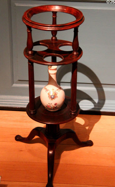 Wash basin stand on tripod with cutouts for soap dishes & lower shelf for water bottle (1765-90) from Newport, RI at Metropolitan Museum of Art. New York, NY.