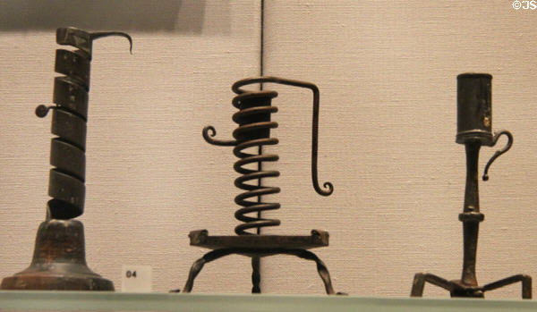 French & Swiss iron candleholders (17th-19thC) 2 using screw mechanism to raise flame to exactly right height for reading at Cooper Hewett Museum. New York City, NY.