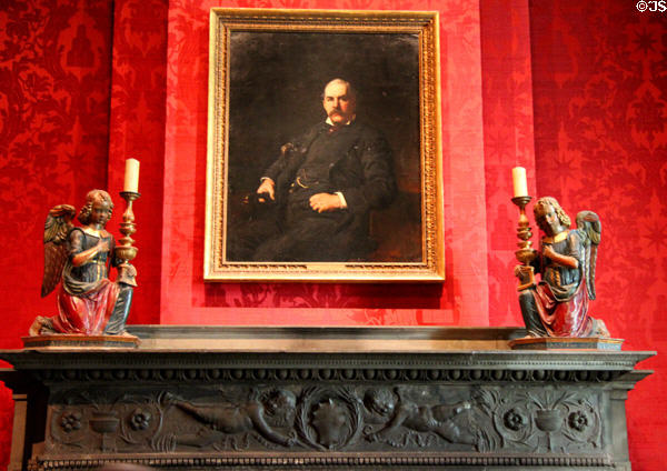 Fireplace carved mantel holding Pierpont Morgan (1888) portrait plus kneeling angel candlesticks (c1540-50) from Italy at Morgan Library. New York City, NY.